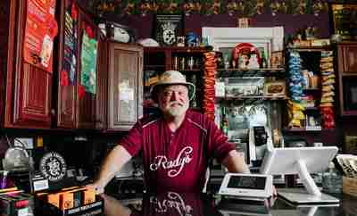 Image of Rudy Mahara behind the counter at Rudy's Cigar Shop
