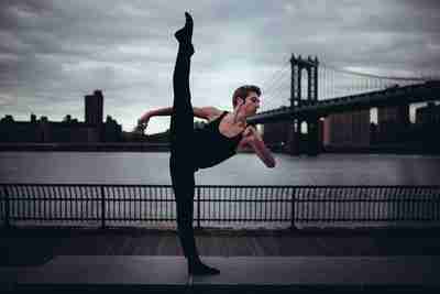 Image of Josh Zacher in front of the Brooklyn Bridge doing ballet.