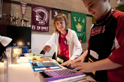 image of female student seated at classroom desk looking back at camera and smiling